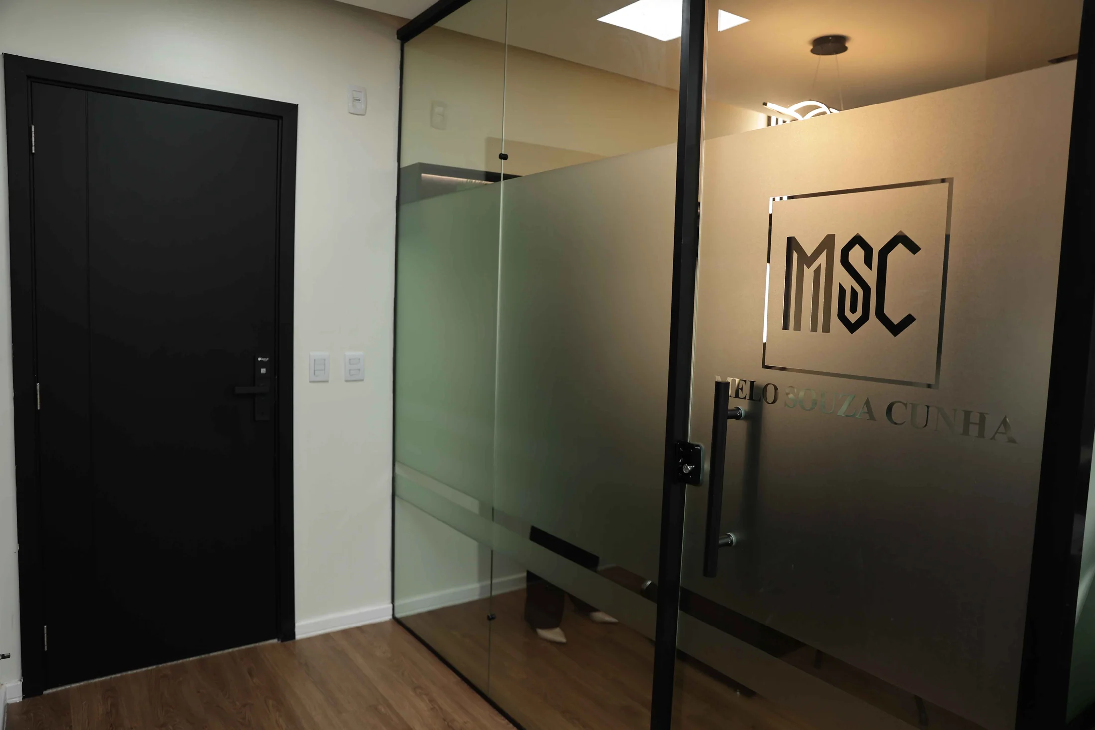 Entrada do escritório do MSC Advocacia, com a marca aplicada na porta de vidro.