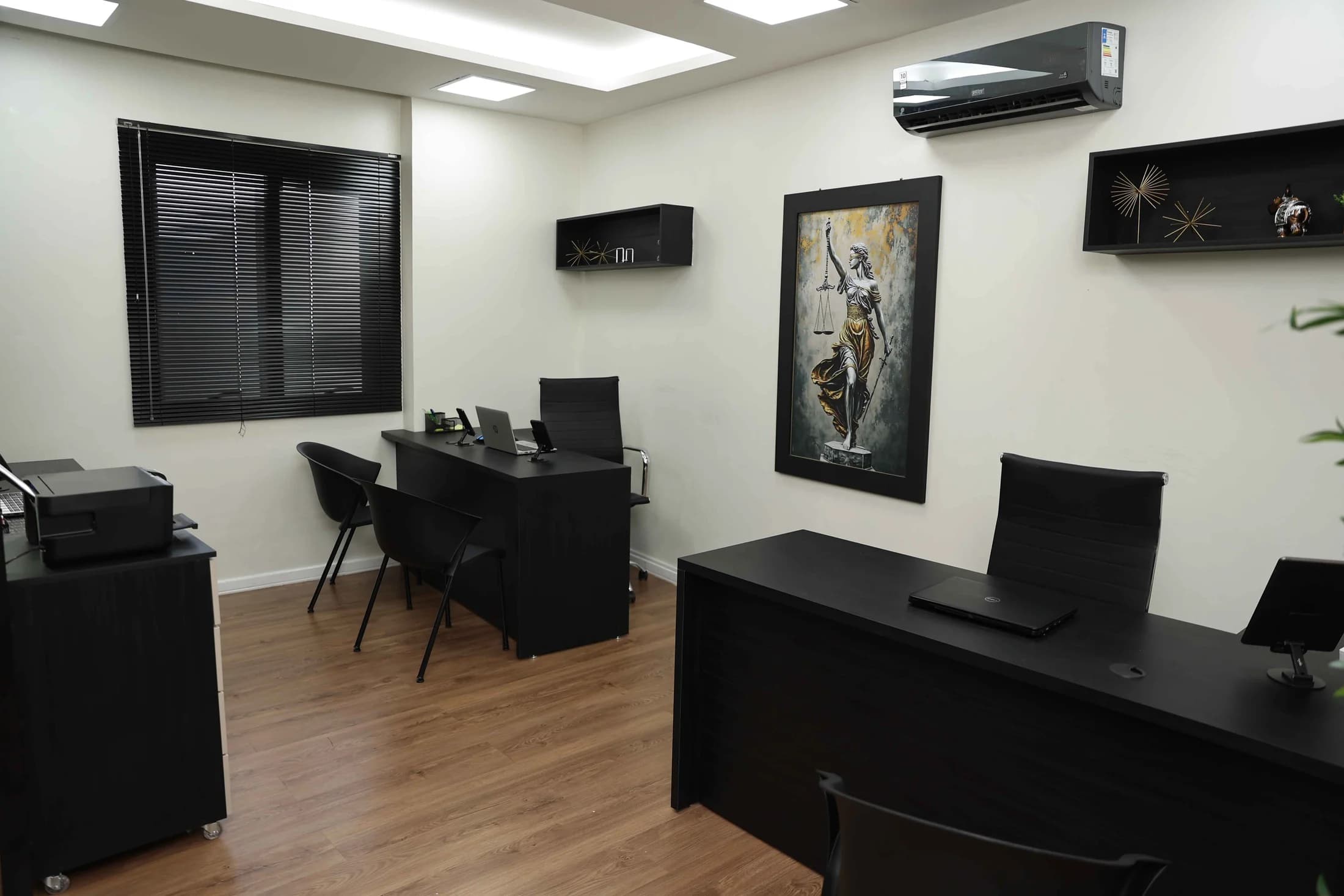 Sala de trabalho do MSC Advocacia, com mobiliário escuro e iluminação embutida.