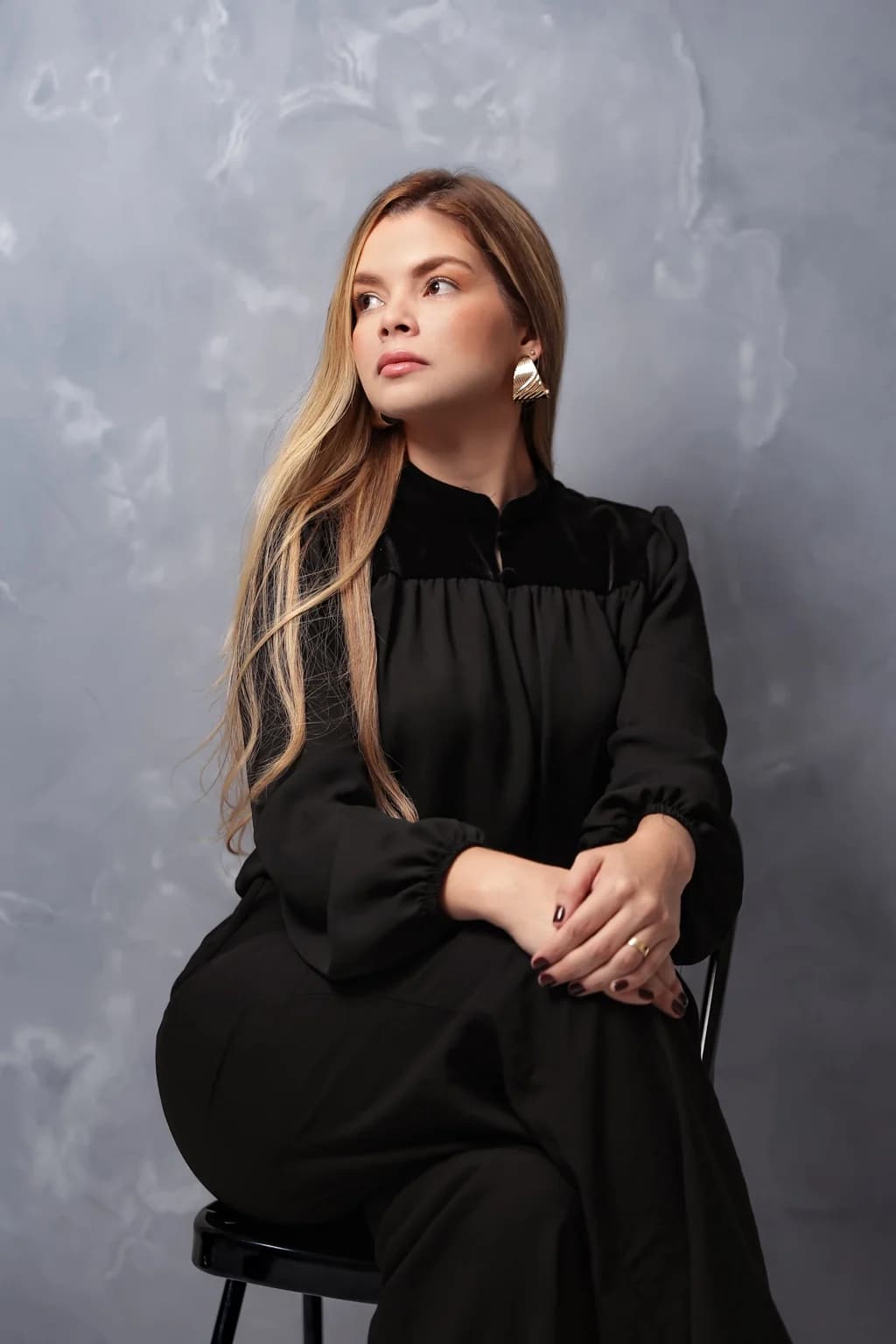 Tainá Cunha, advogada e fundadora do MSC Advocacia, sentada em estúdio com fundo cinza.